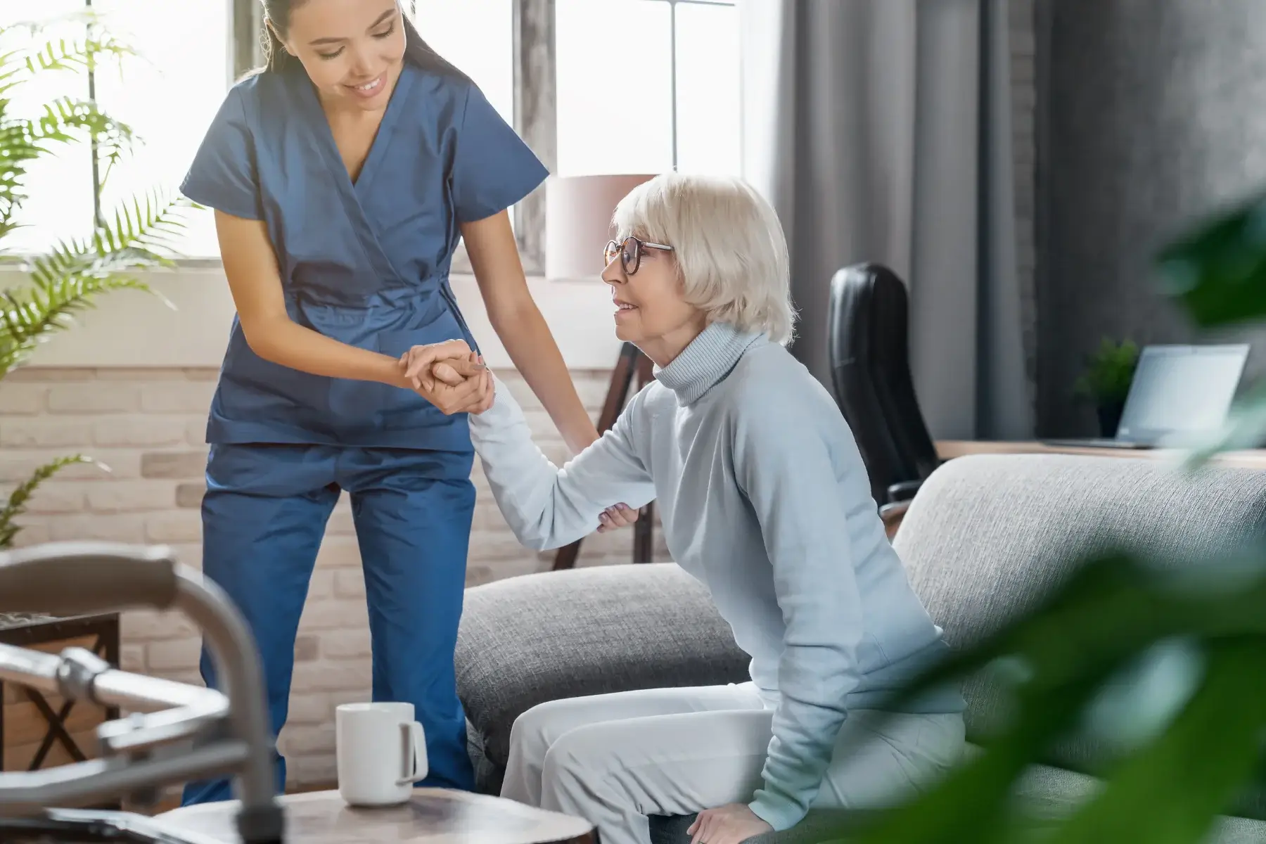 Nurse providing in-home care to a person seated in a chair